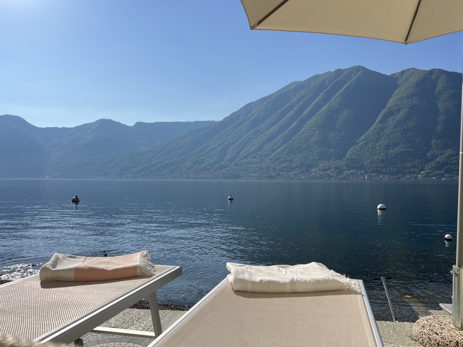 Blue sky above lake, hill, umbrella