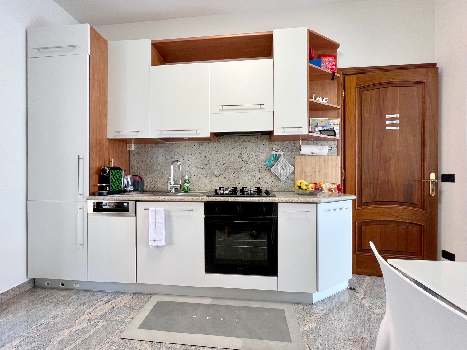 Kitchen has wood cabinet and oven