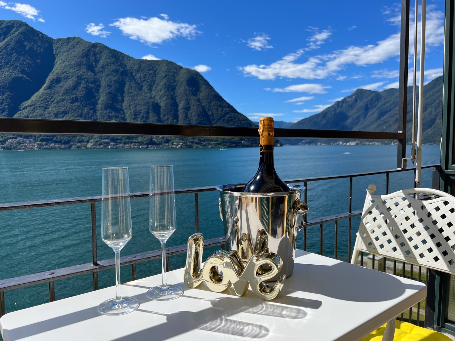 Outdoor furniture by lake with cloudy blue sky